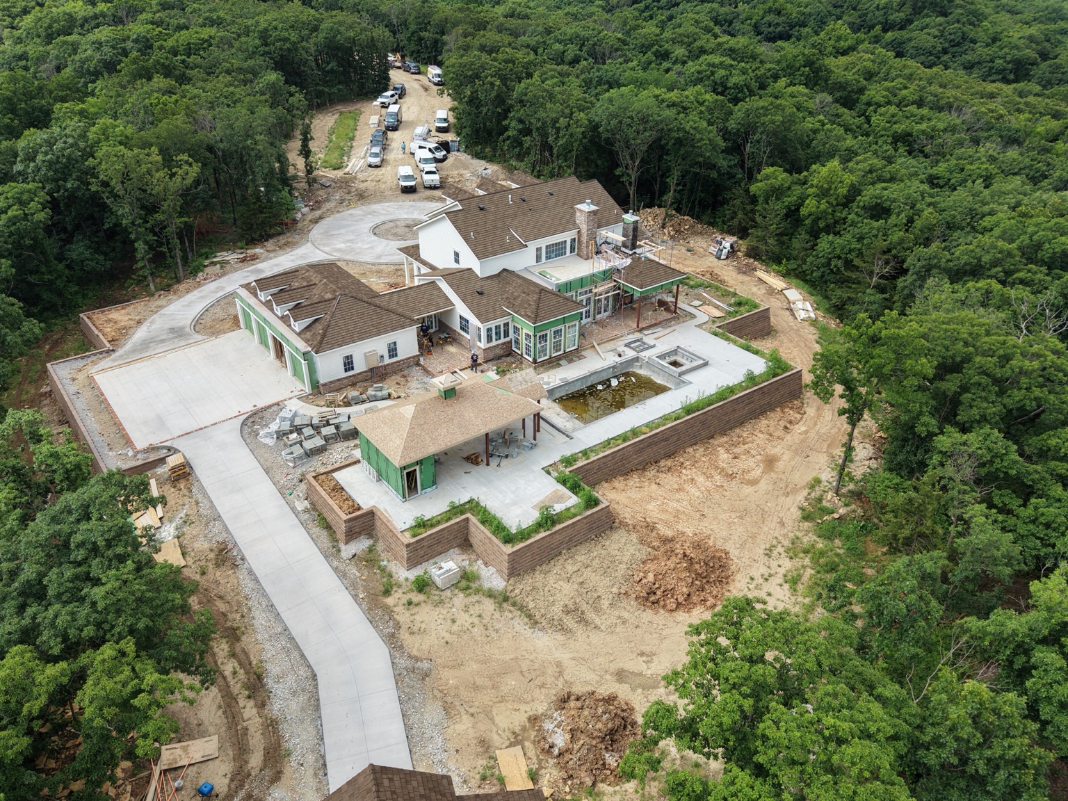 Rear aerial overview of a custom home, pool and retaining walls